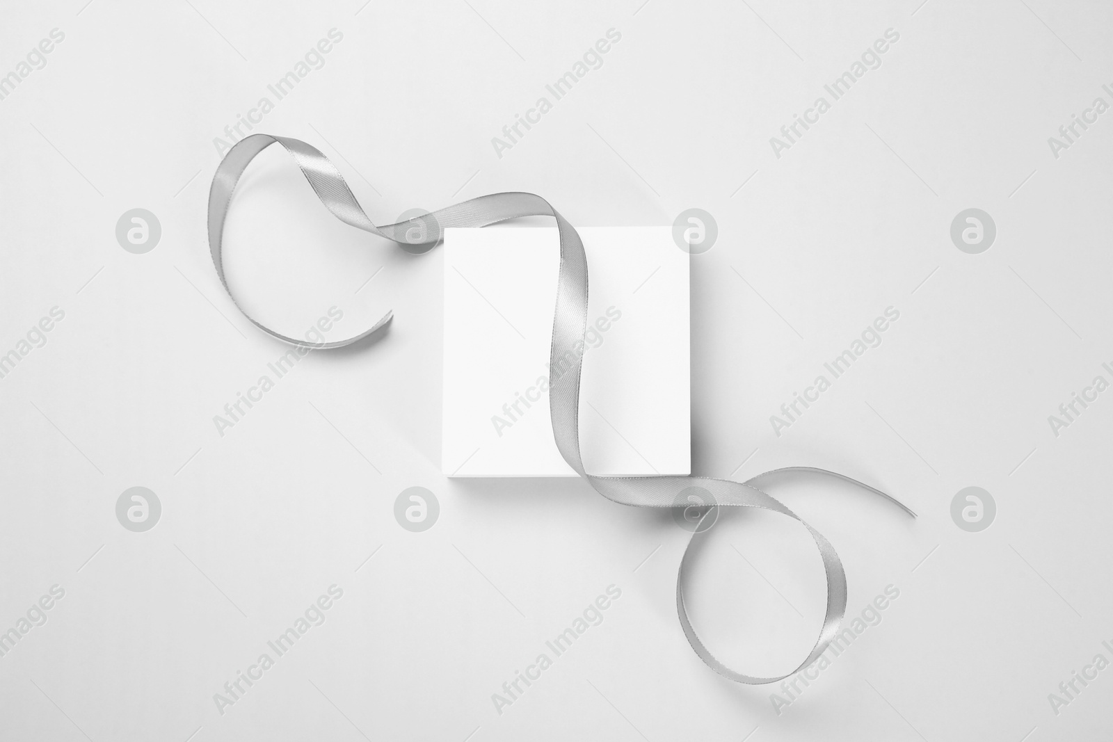 Photo of Beautiful grey ribbon and podium on white background, top view