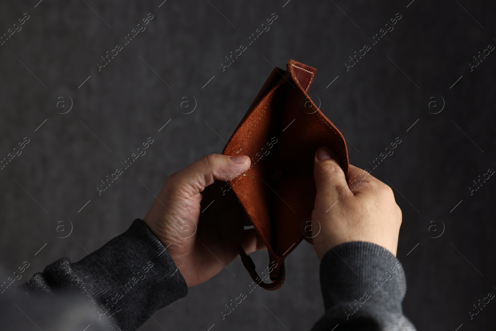 Photo of Man with empty wallet on dark background, closeup