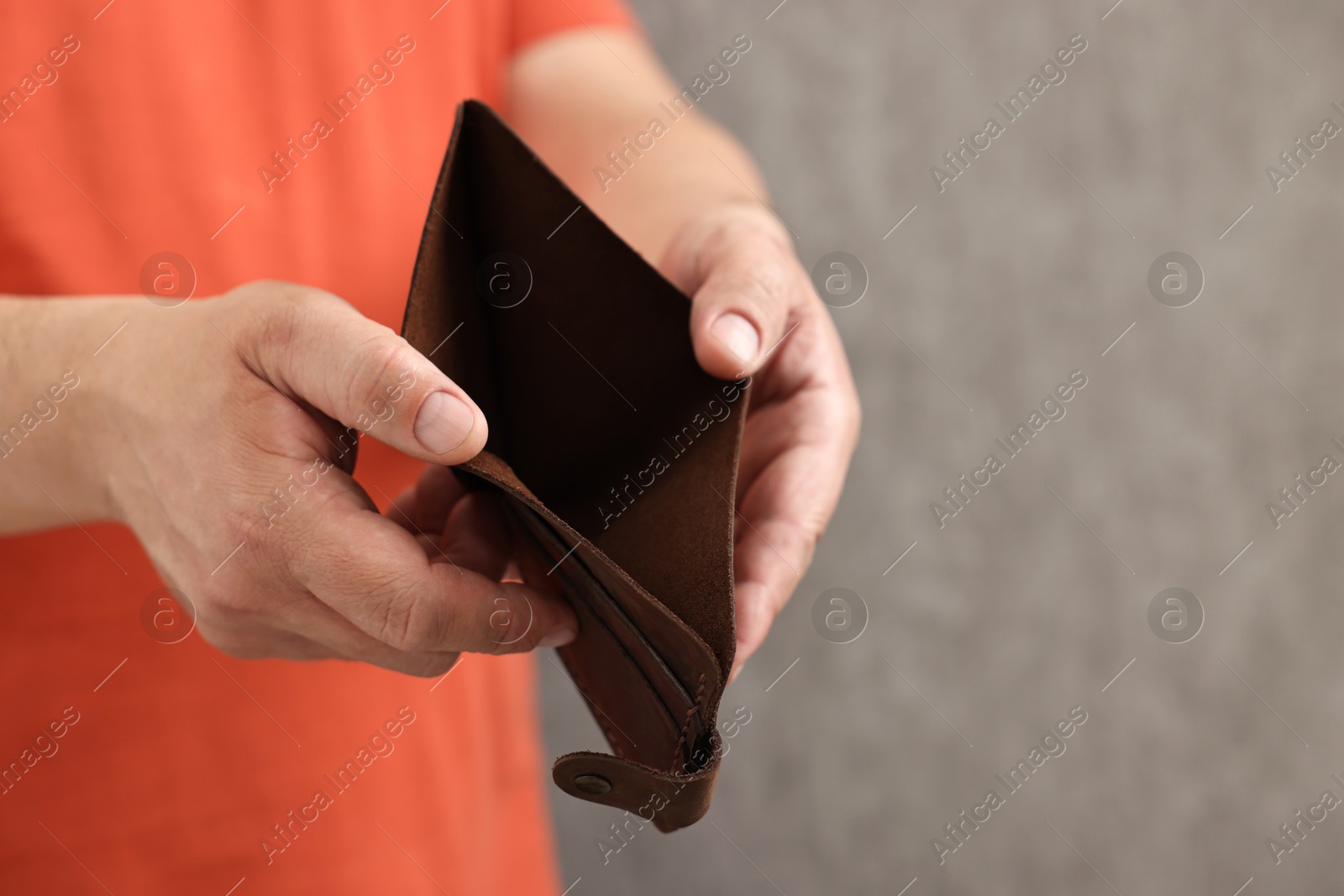 Photo of Man with empty wallet on blurred background, closeup. Space for text