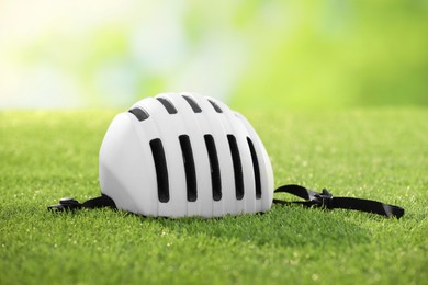 Photo of One white protective helmet on green grass