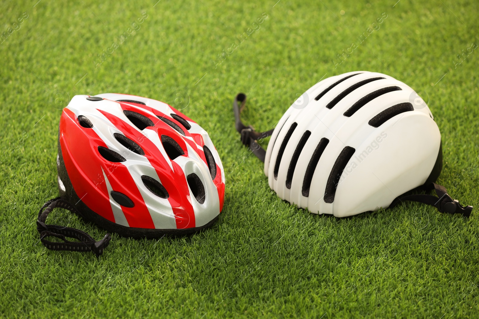 Photo of Two protective helmets on green grass. Sports equipment