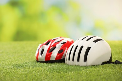 Photo of Two protective helmets on green grass, space for text