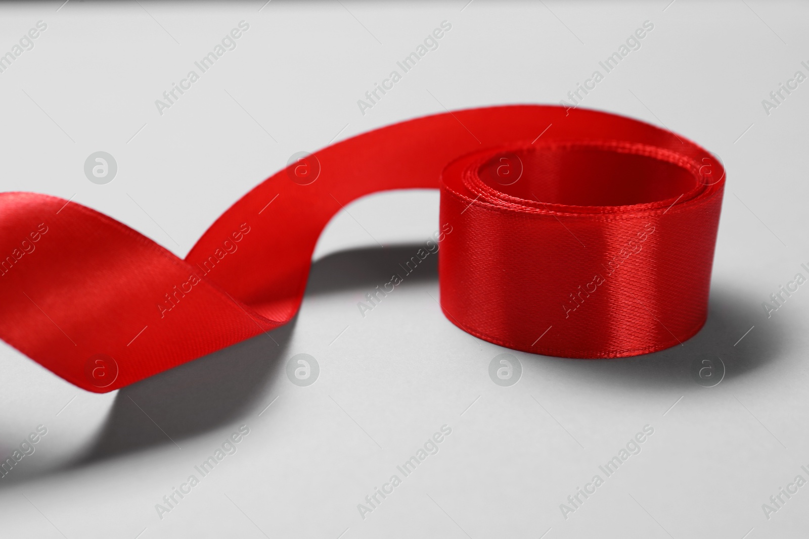 Photo of One beautiful red ribbon on white background, closeup