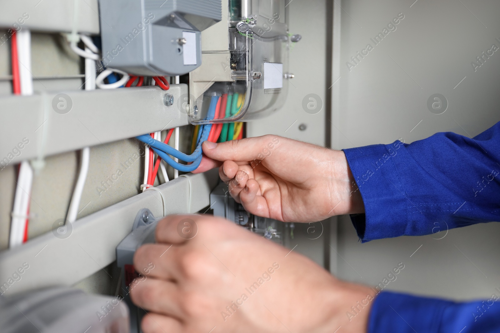 Photo of Electrician installing electricity meter indoors, closeup view