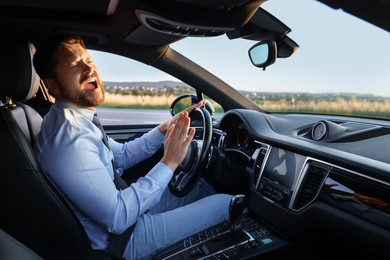 Man singing in car, view from inside