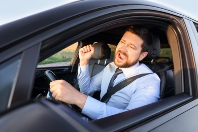 Man singing in car, view from outside