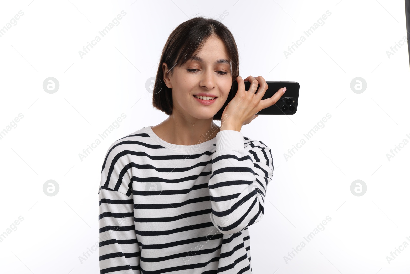 Photo of Beautiful woman with smartphone listening to voice message on white background