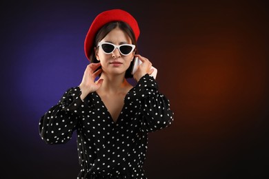 Photo of Stylish woman listening to voice message via smartphone on color background