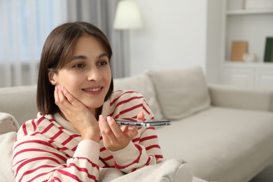 Photo of Beautiful woman recording voice message via smartphone at home