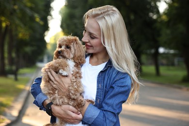 Beautiful young woman with cute dog in park