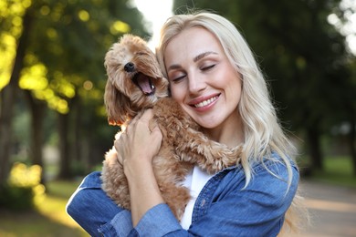 Beautiful young woman with cute dog in park