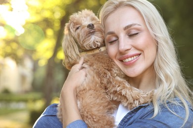 Beautiful young woman with cute dog in park