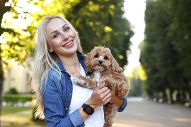 Beautiful young woman with cute dog in park