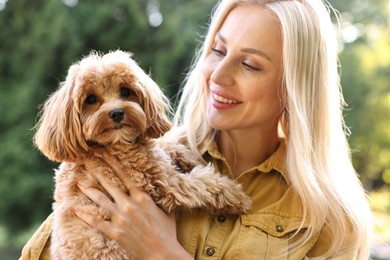 Beautiful young woman with cute dog in park