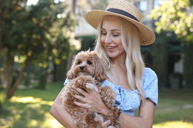 Beautiful young woman with cute dog in park