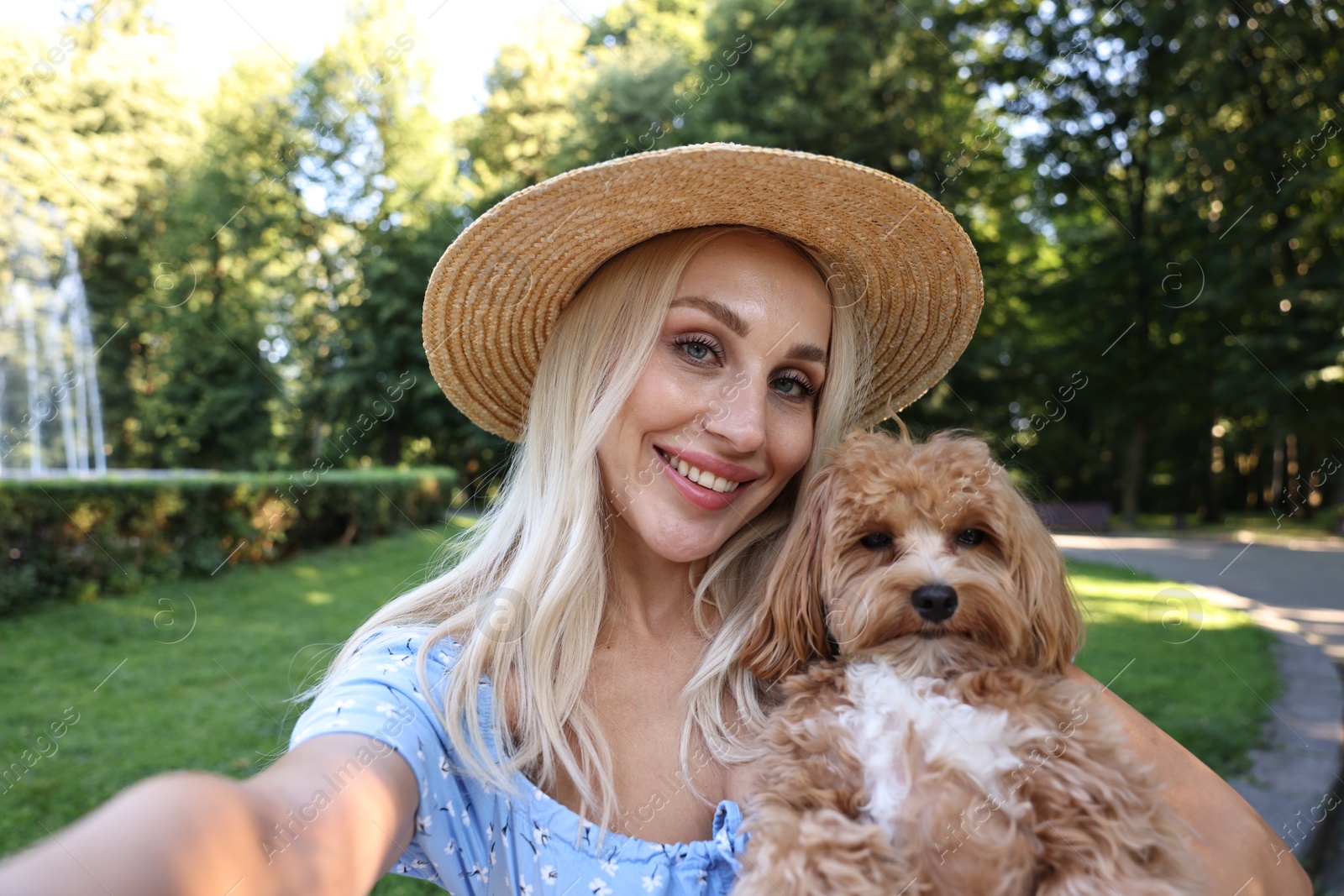 Photo of Beautiful young woman taking selfie with cute dog in park