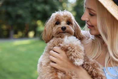 Beautiful young woman with cute dog in park