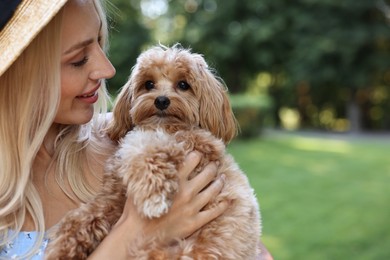 Beautiful young woman with cute dog in park