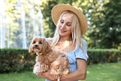 Beautiful young woman with cute dog in park