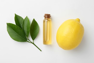 Photo of Bottle of essential oil, lemon and green leaves on white background, flat lay