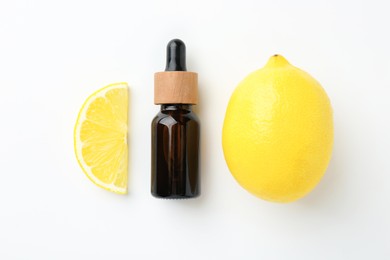 Photo of Bottle of essential oil and lemon on white background, flat lay