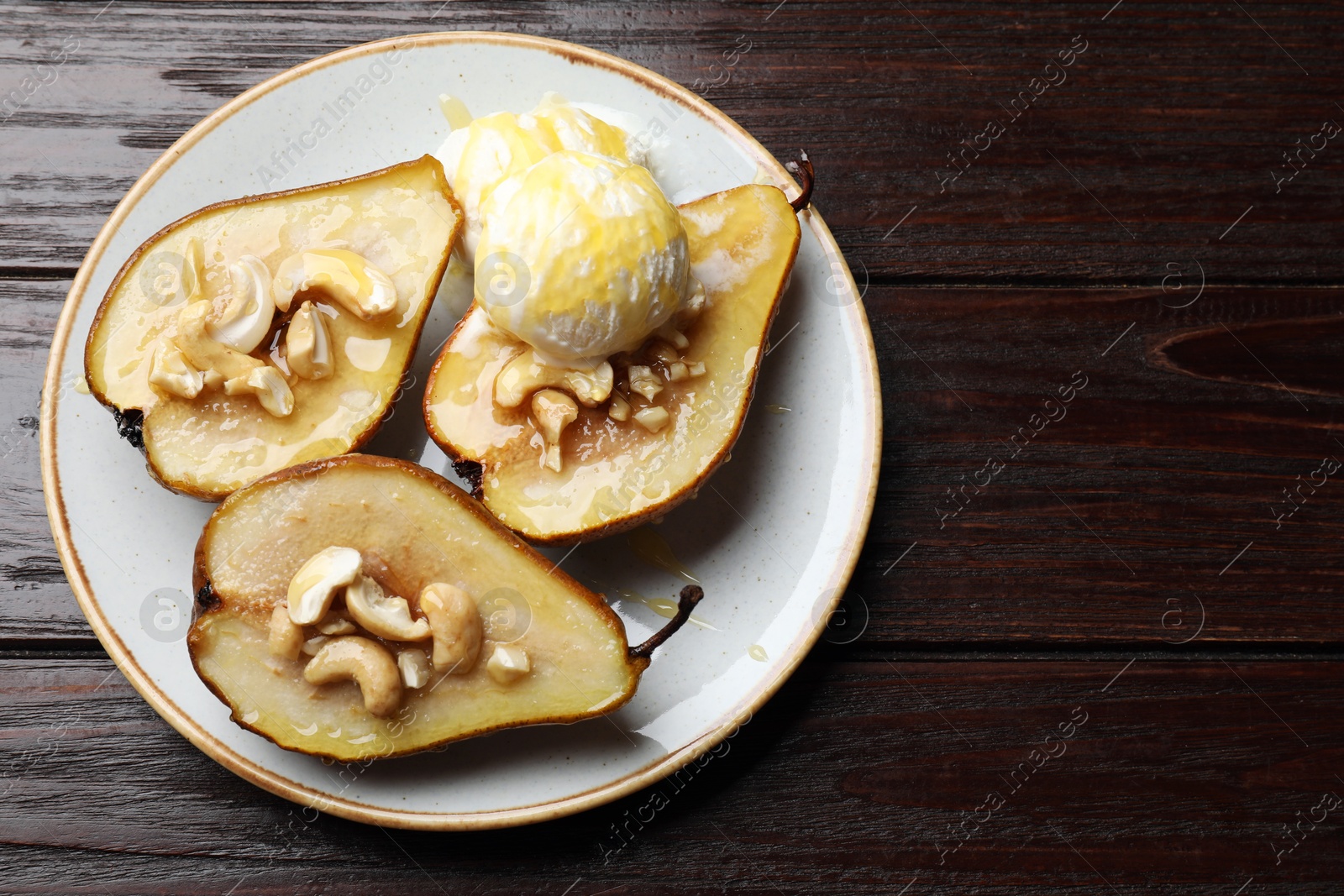 Photo of Delicious baked pears with nuts, ice cream and honey on wooden table, top view. Space for text