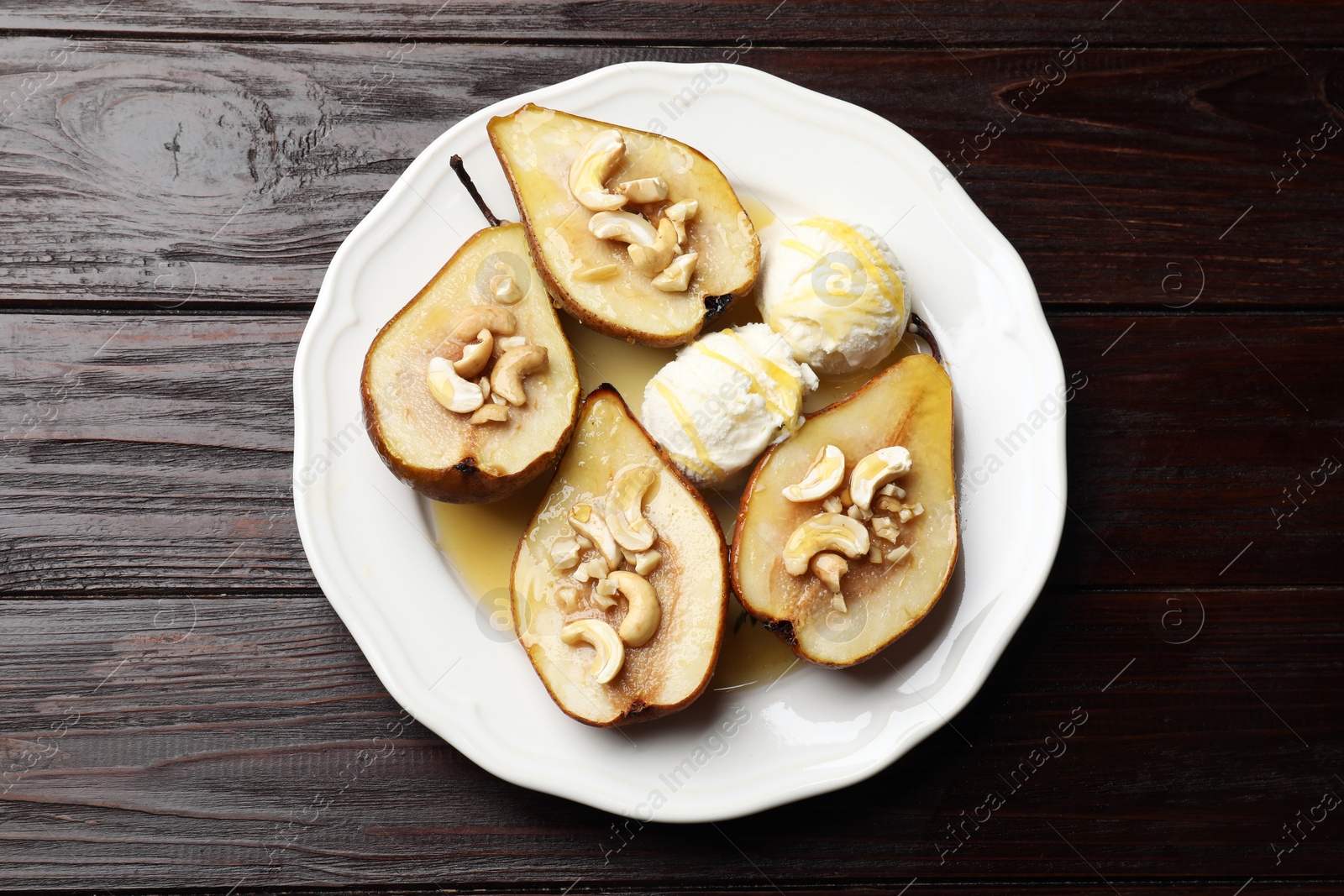 Photo of Delicious baked pears with nuts, ice cream and honey on wooden table, top view