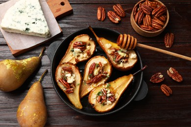 Photo of Delicious baked pears with nuts, blue cheese and honey on wooden table, flat lay