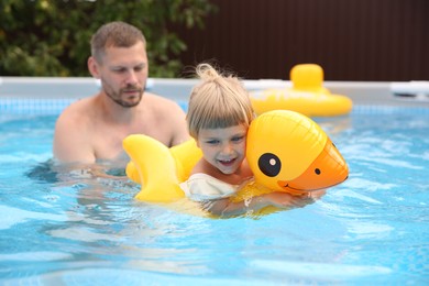 Photo of Happy daughter and her father swimming in pool