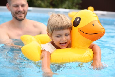 Happy daughter and her father swimming in pool