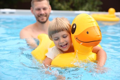 Photo of Happy daughter and her father swimming in pool