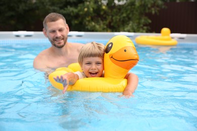 Photo of Happy daughter and her father swimming in pool