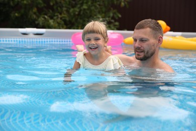 Photo of Happy daughter and her father having fun in swimming pool