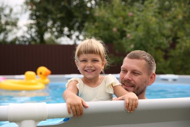 Photo of Happy daughter and her father resting in swimming pool