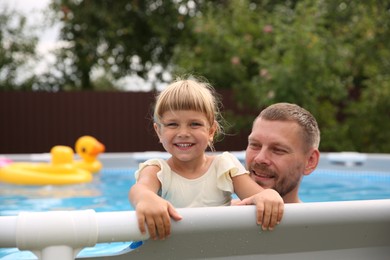 Happy daughter and her father resting in swimming pool