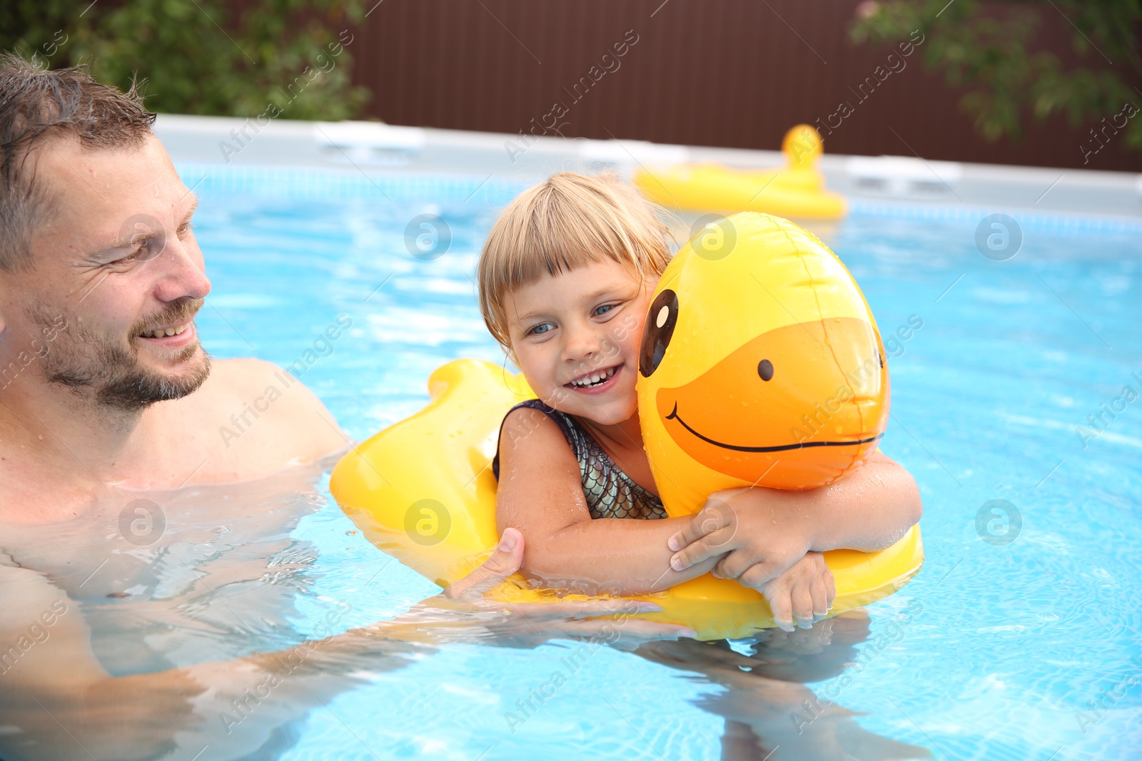 Photo of Happy daughter and her father having fun in swimming pool