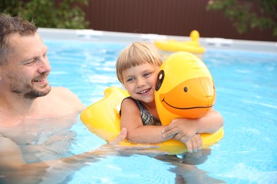 Happy daughter and her father having fun in swimming pool