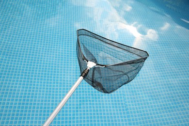 Photo of One skimmer net above swimming pool, closeup