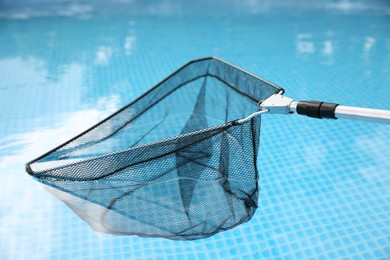 Photo of One skimmer net above swimming pool, closeup