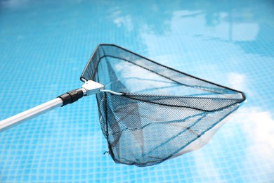 One skimmer net above swimming pool, closeup