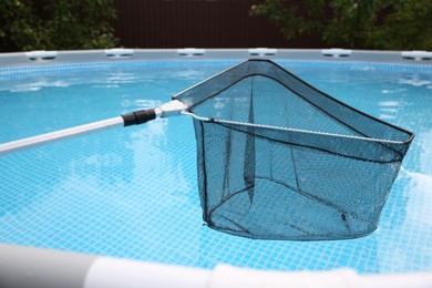 One skimmer net above swimming pool, closeup