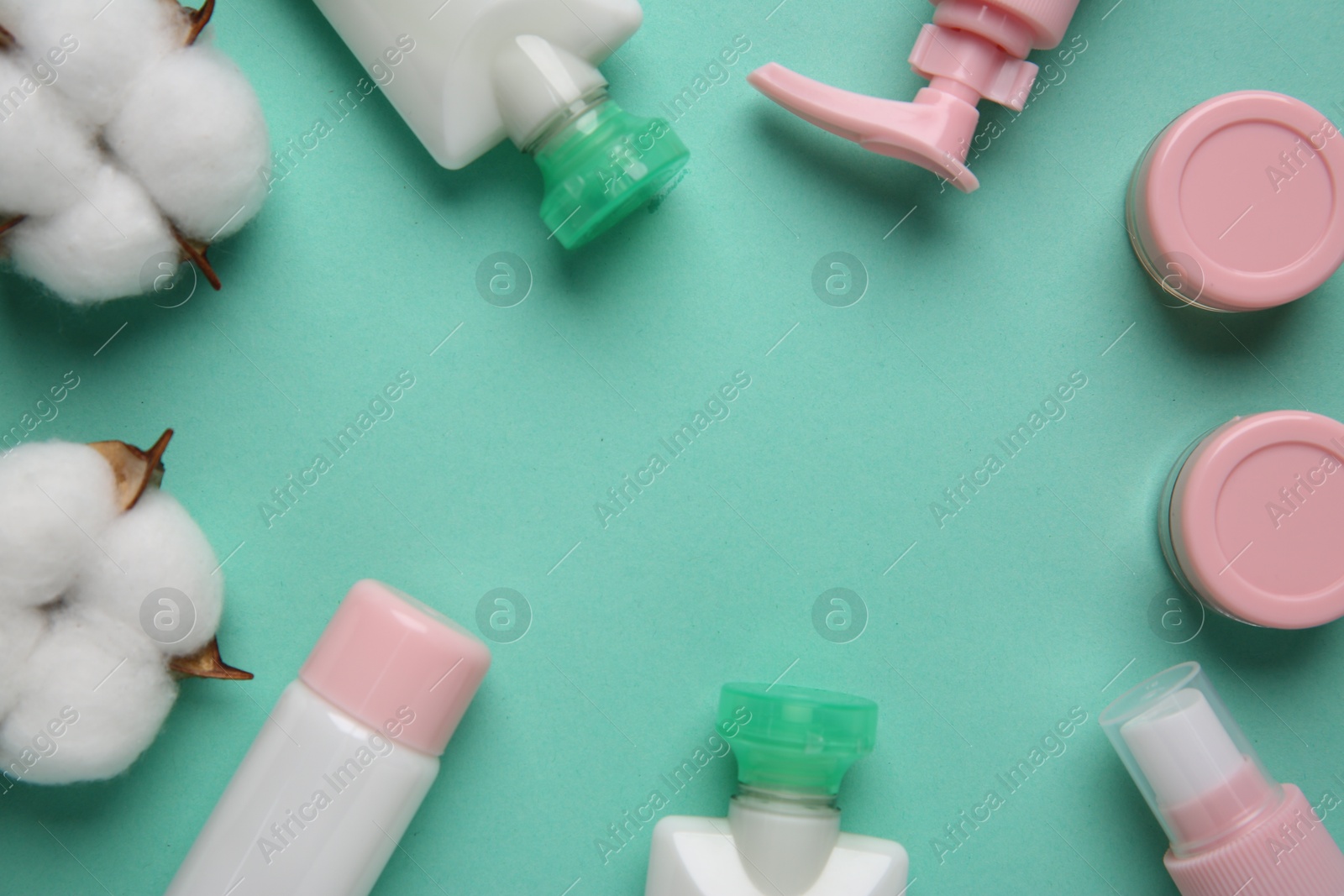 Photo of Different cosmetic products and cotton flowers on turquoise background, flat lay. Space for text