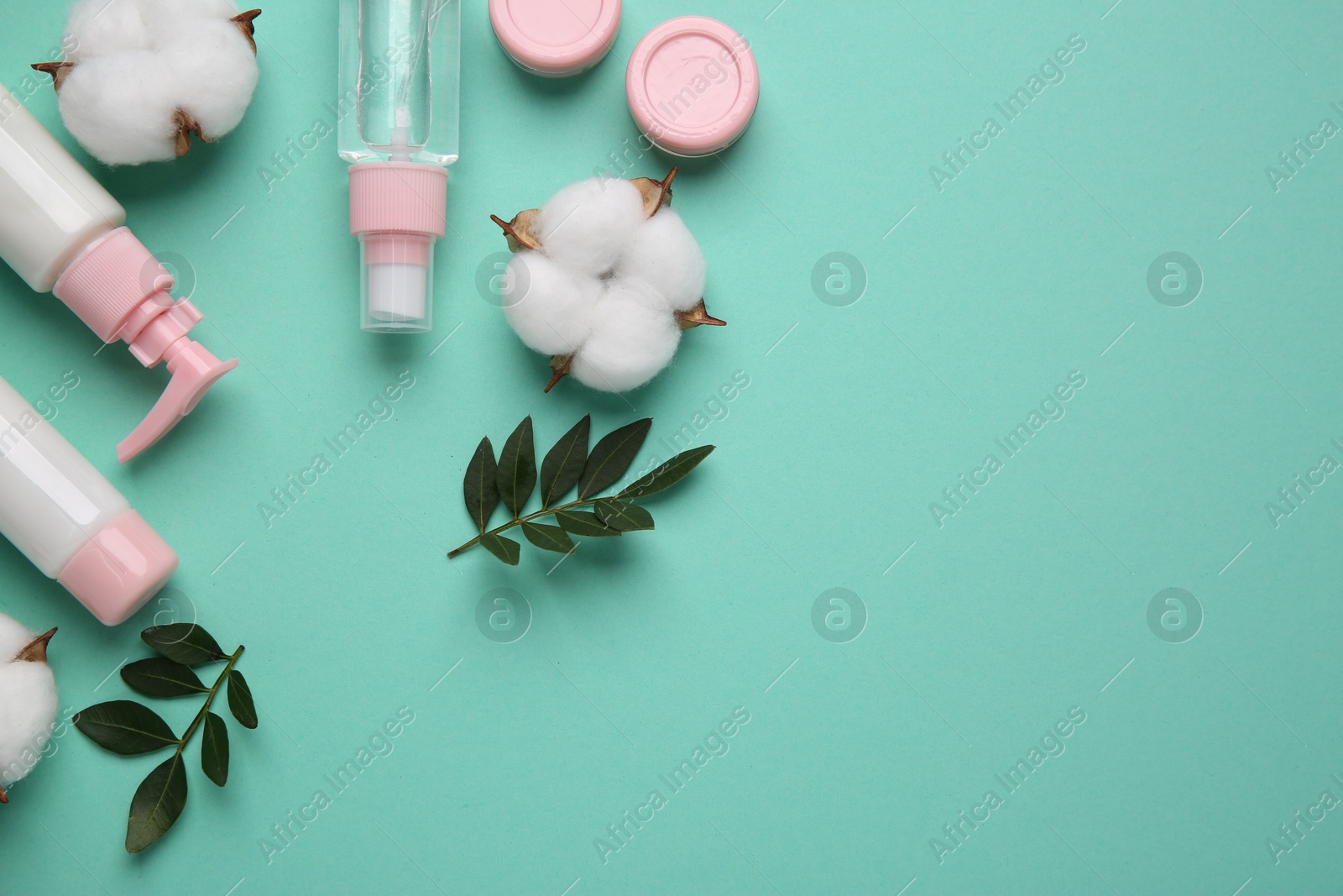 Photo of Different cosmetic products, leaves and cotton flowers on turquoise background, flat lay. Space for text