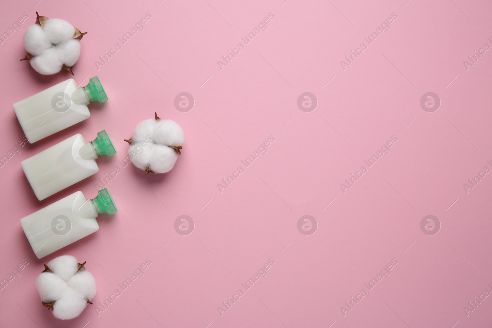 Photo of Different cosmetic products and cotton flowers on pink background, flat lay. Space for text