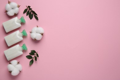 Photo of Different cosmetic products, leaves and cotton flowers on pink background, flat lay. Space for text