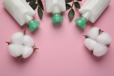 Photo of Different cosmetic products, leaves and cotton flowers on pink background, flat lay. Space for text