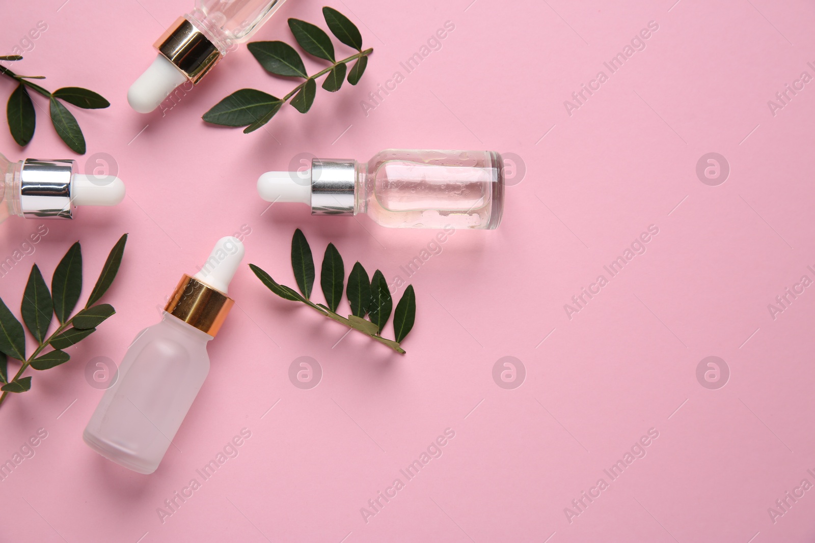 Photo of Different cosmetic products and green leaves on pink background, flat lay. Space for text