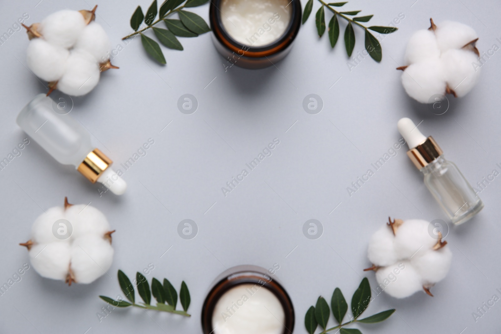 Photo of Different cosmetic products, leaves and cotton flowers on grey background, flat lay. Space for text