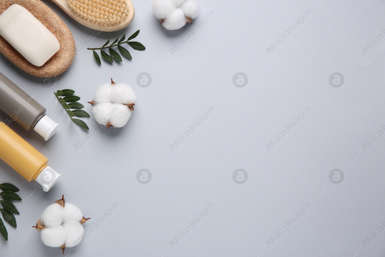 Photo of Different cosmetic products, leaves and cotton flowers on grey background, flat lay. Space for text