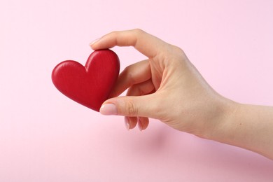 Photo of Woman holding red heart on pink background, closeup